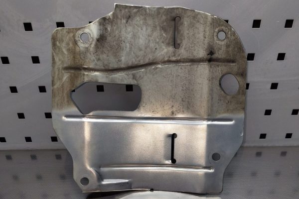 En metalldel som är halvt våtpolerad vilket ger en tydlig kontrast mellan den polerade och en opolerade delen.